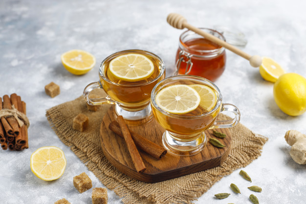 A cup of tea,brown sugar,honey and lemon on concrete  background